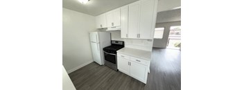 A kitchen with white cabinets and a black stove top oven.