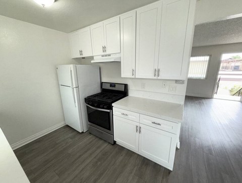 A kitchen with white cabinets and a black stove top oven.