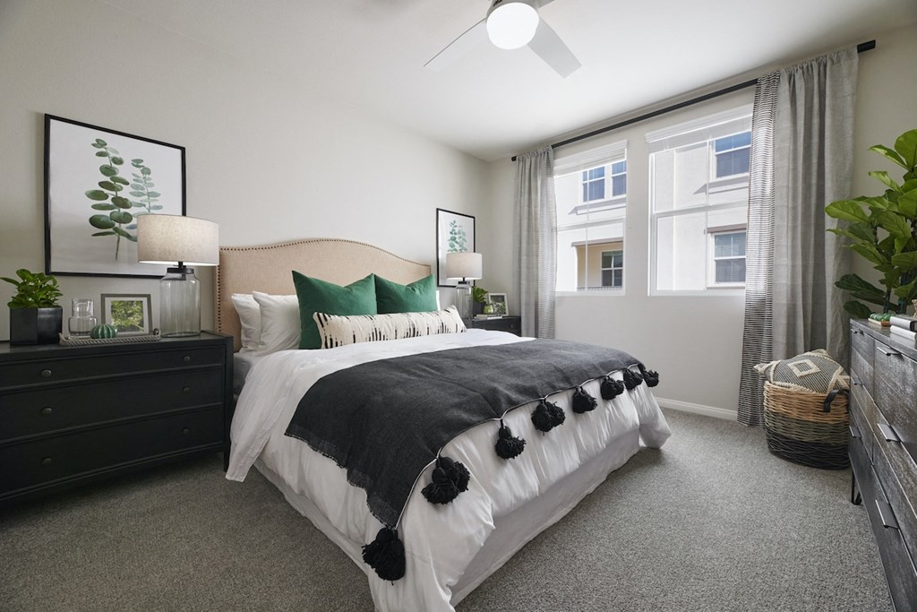 1, 2, & 3-BR Apartments In Riverside, CA - Lincoln Village - Bedroom With Comfortable Bedding, Carpet Flooring, Double Nightstands, 2 Windows, And Dark Wood Dresser