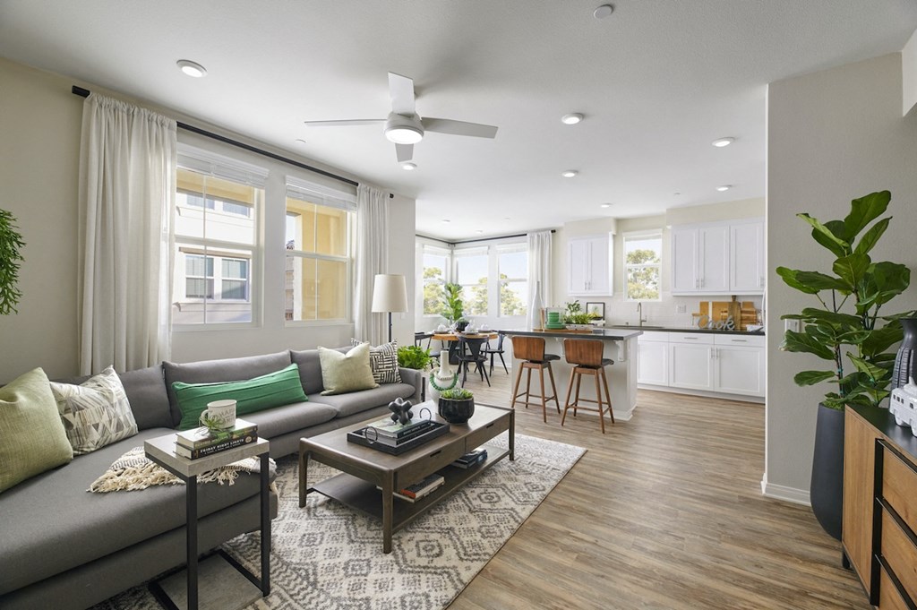Apartments Riverside, CA - Living Room With Grey Couch, Wooden Coffee Table, And Patterned Area Rug