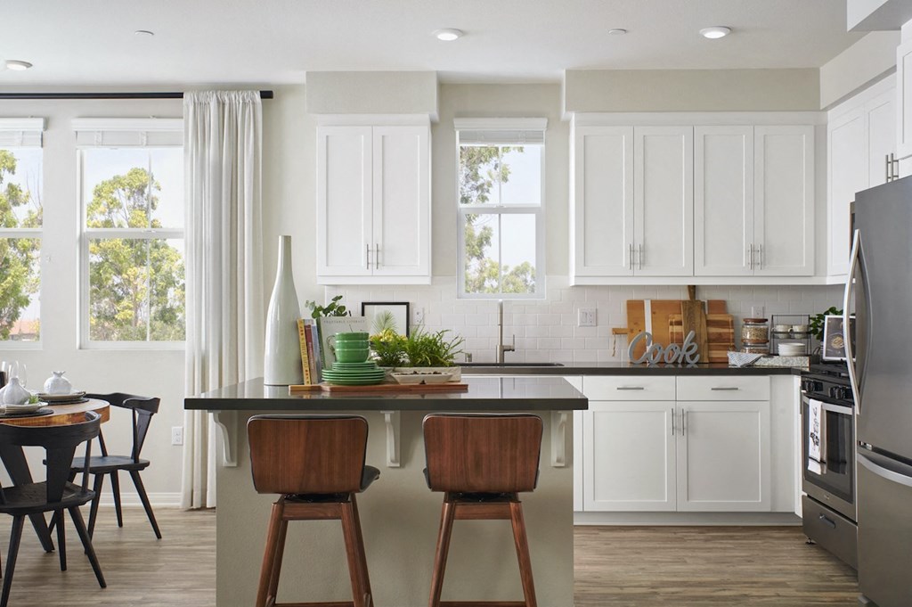 Apartments In Riverside - Kitchen With Stainless-Steel Appliances, Kitchen Island, And White Modern Cabinets
