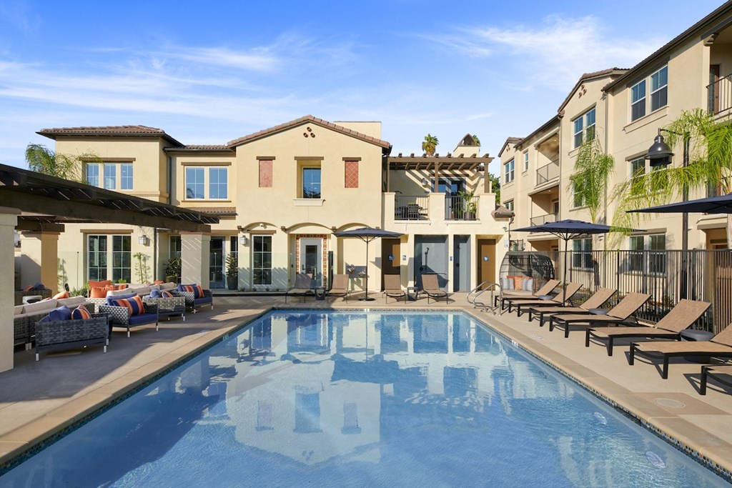 Apartments For Rent In Riverside, CA - Lincoln Village - Resort-Style Swimming Pool Outside With Sundeck, Lounge Chairs And Umbrellas