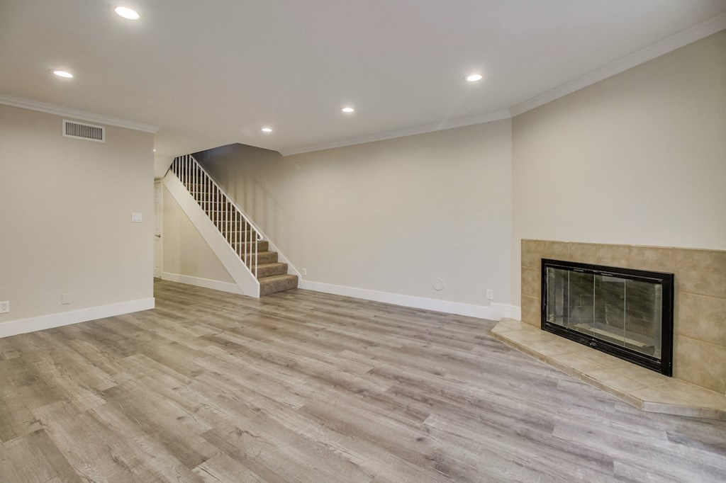 A living room with a fireplace and a staircase.