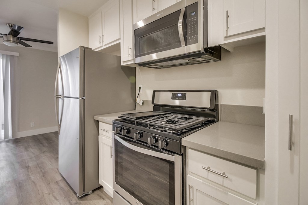A modern kitchen with a stainless steel refrigerator, microwave, and stove.