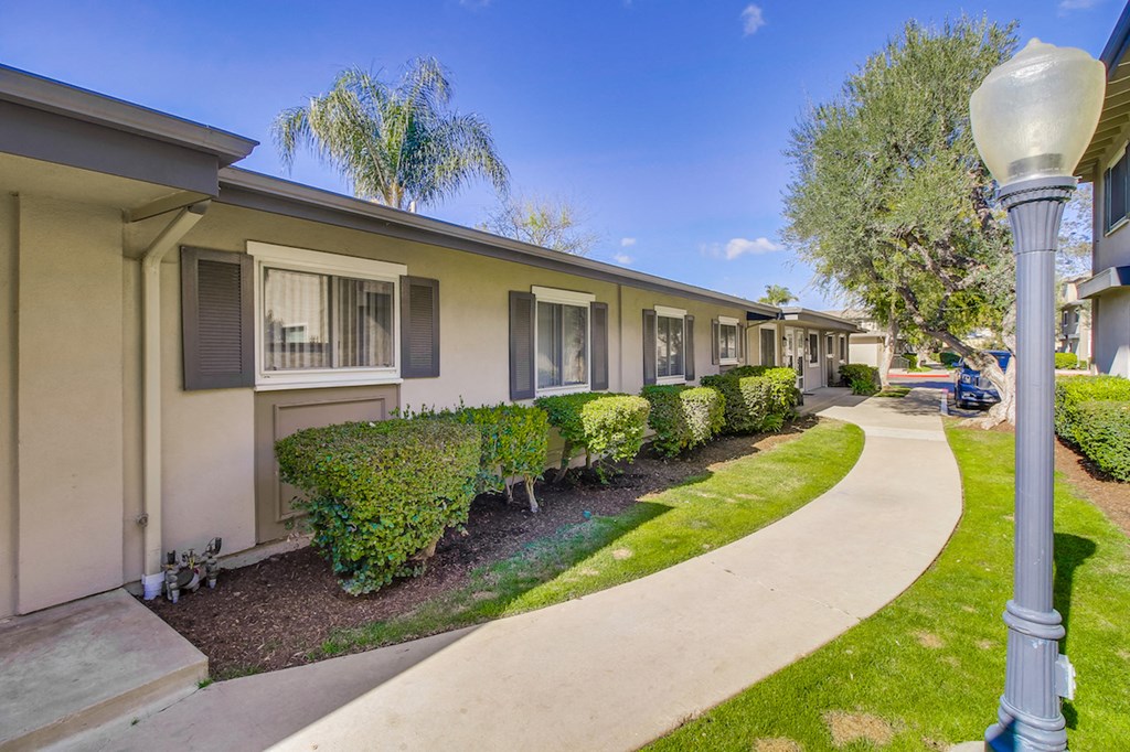 A row of houses with a sidewalk and street light.