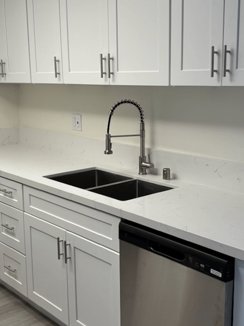 A kitchen with a sink and a dishwasher.
