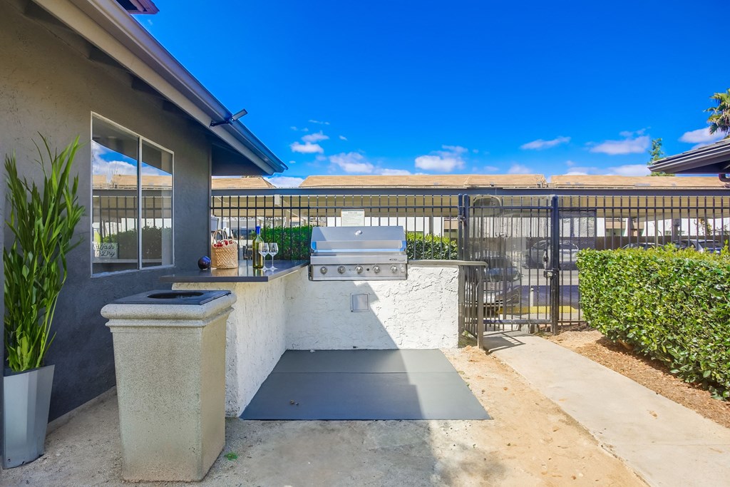 the backyard has an outdoor bar with a grill and a fence