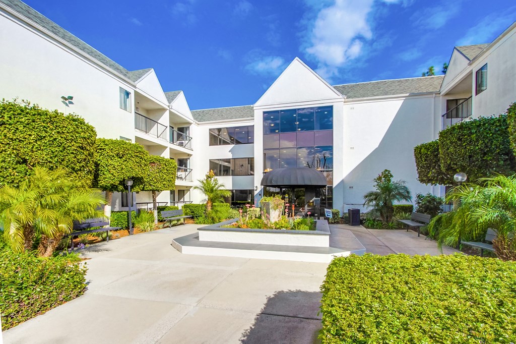 the courtyard of an apartment building with a fountain in the center
