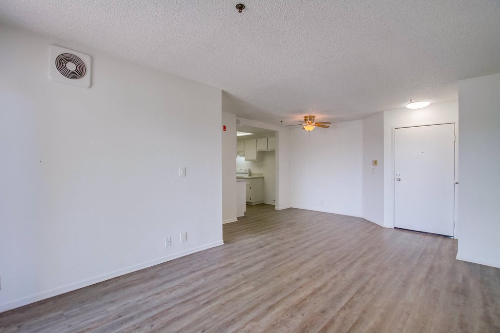 an empty living room with white walls and wood floors