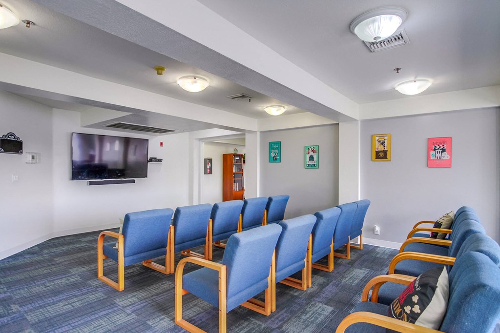 Theater with blue chairs and a tv