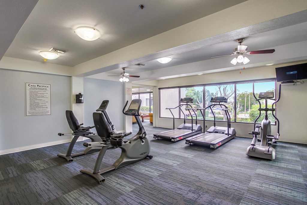 a gym with exercise machines and a window