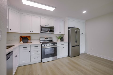 A kitchen with white cabinets and stainless steel appliances.