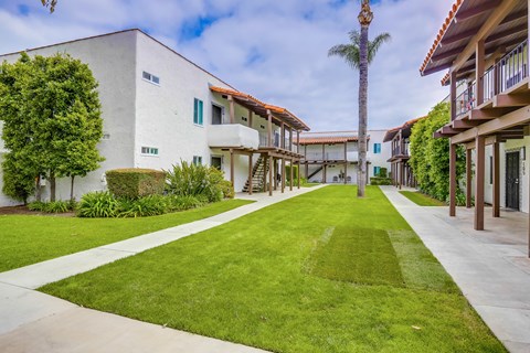 A row of houses with a green lawn in front.