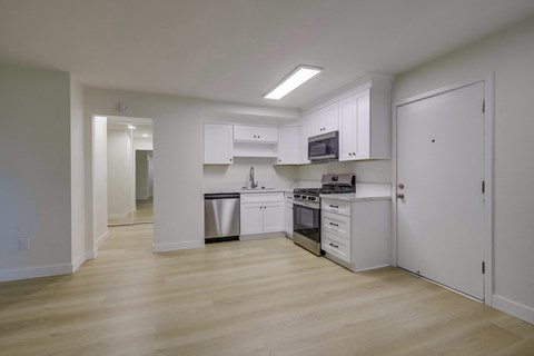 A kitchen with white cabinets and appliances.