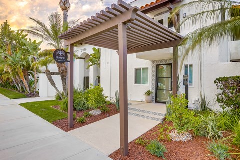 A white building with a brown awning and a sign that says "Leaf".