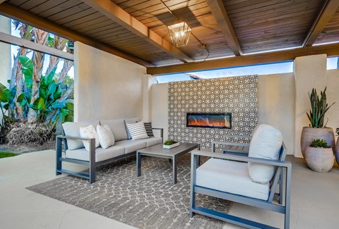 A patio with a fireplace and furniture.
