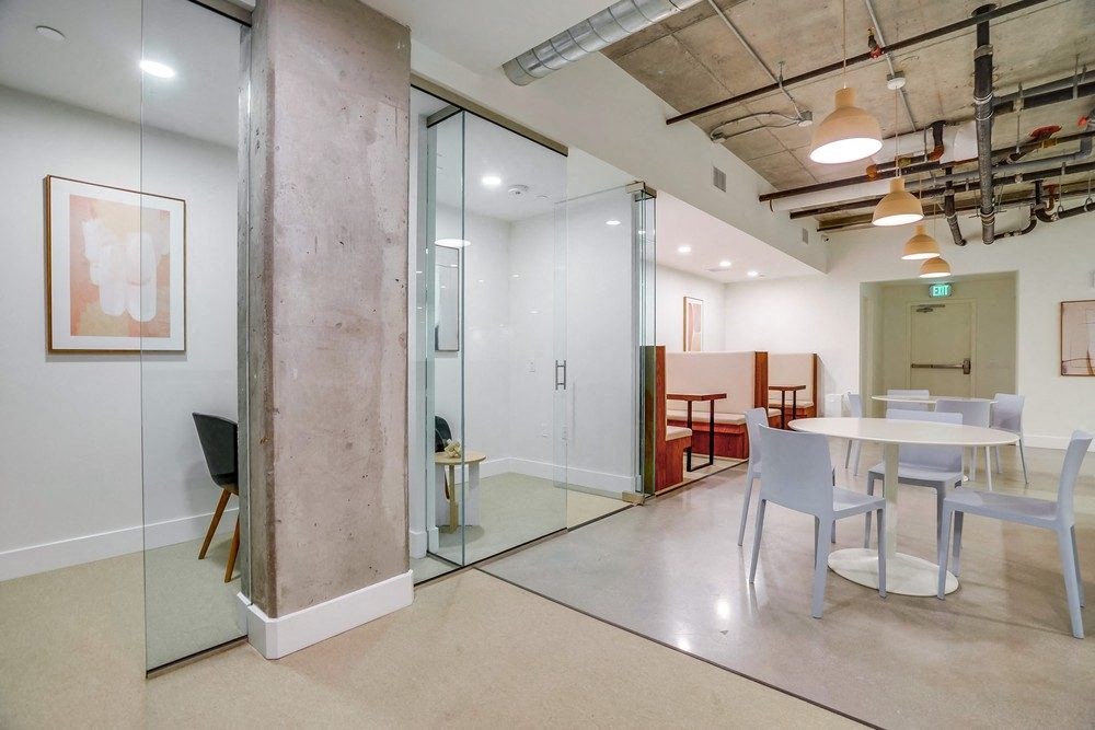 a conference room with a table and chairs and a glass wall