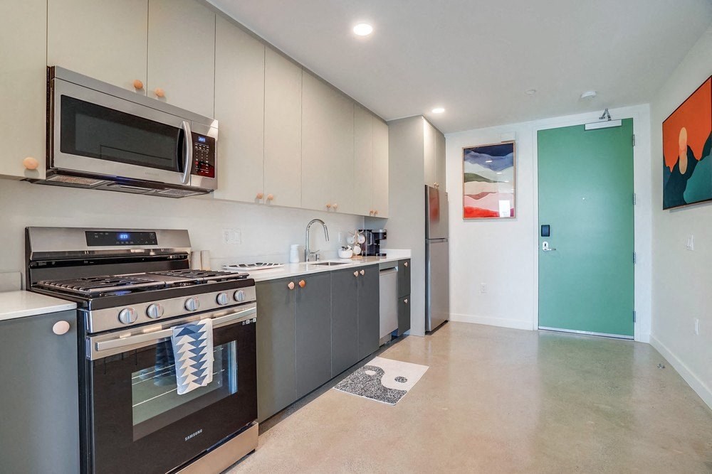 a modern kitchen with stainless steel appliances and a green door