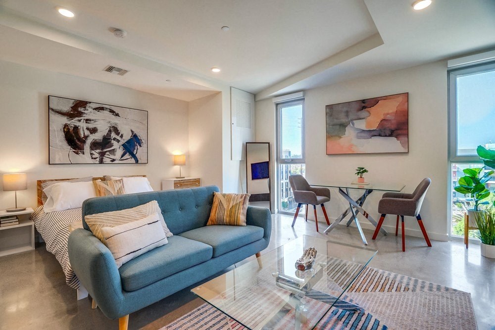 a living room with a blue couch and a table with chairs