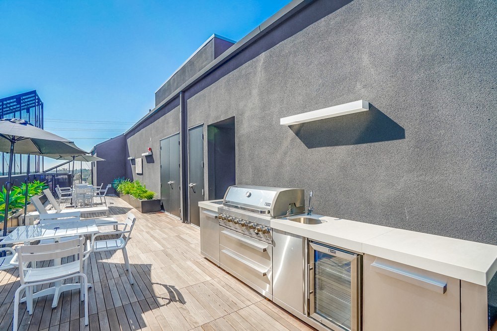 a patio with a grill and a table with chairs