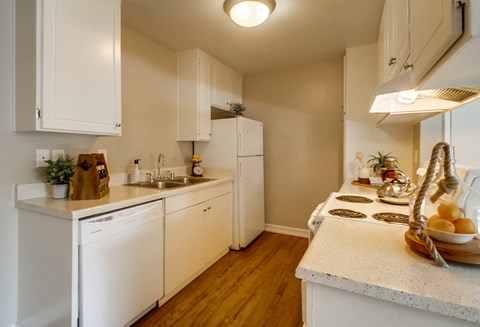 a kitchen with white appliances and counter tops and a sink