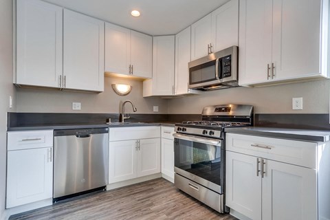 a kitchen with white cabinets and stainless steel appliances