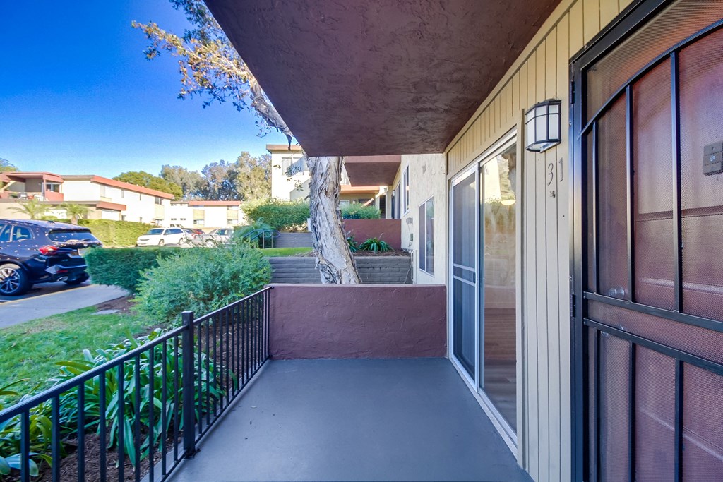 a balcony with a door and a street in the background