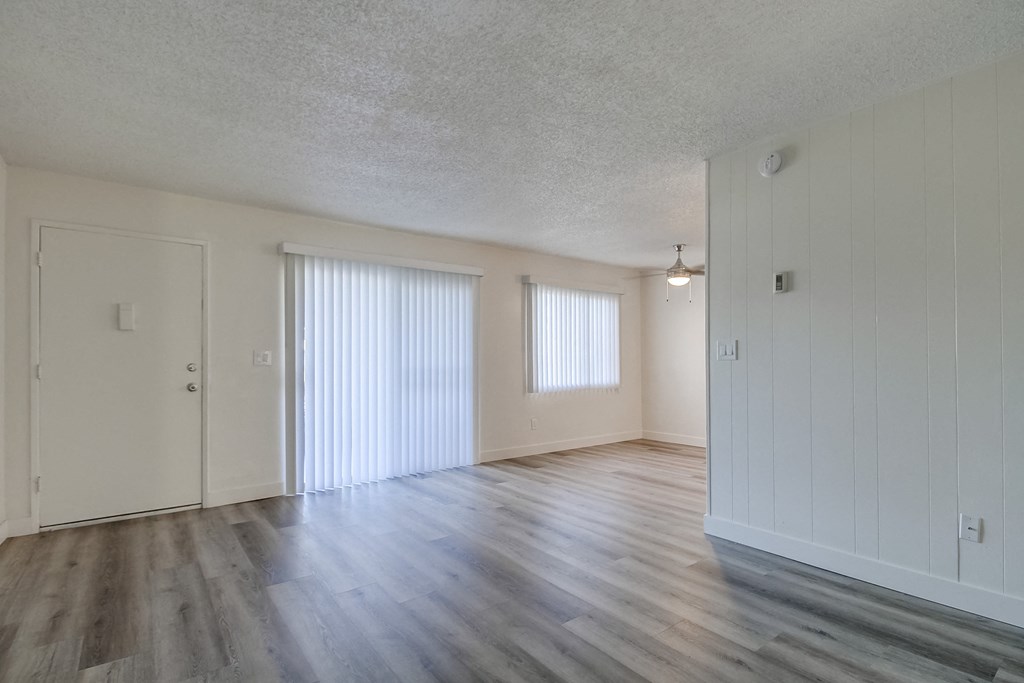 an empty living room with white walls and wood floors