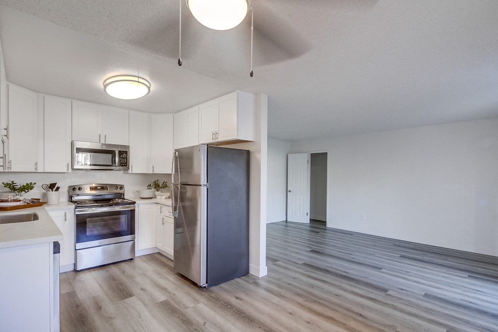 a kitchen with white cabinets and stainless steel appliances