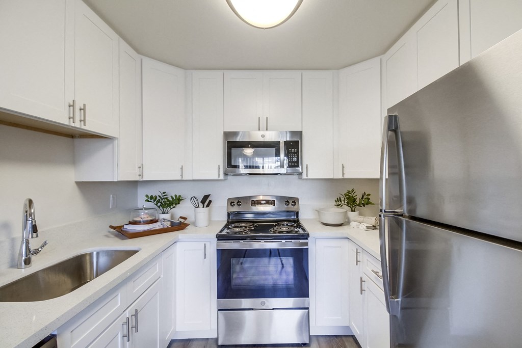 a kitchen with white cabinets and stainless steel appliances