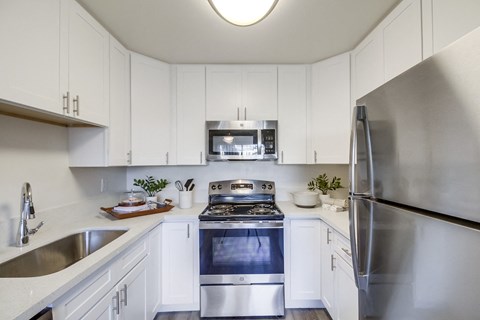 a kitchen with stainless steel appliances and white cabinets