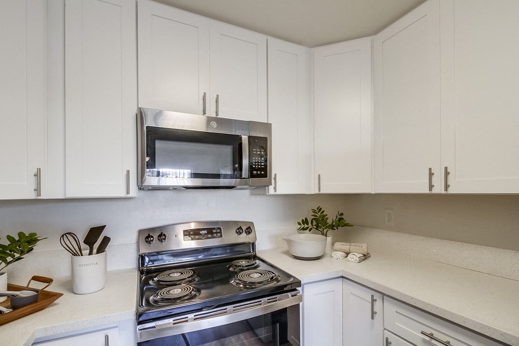 a kitchen with white cabinets and stainless steel appliances
