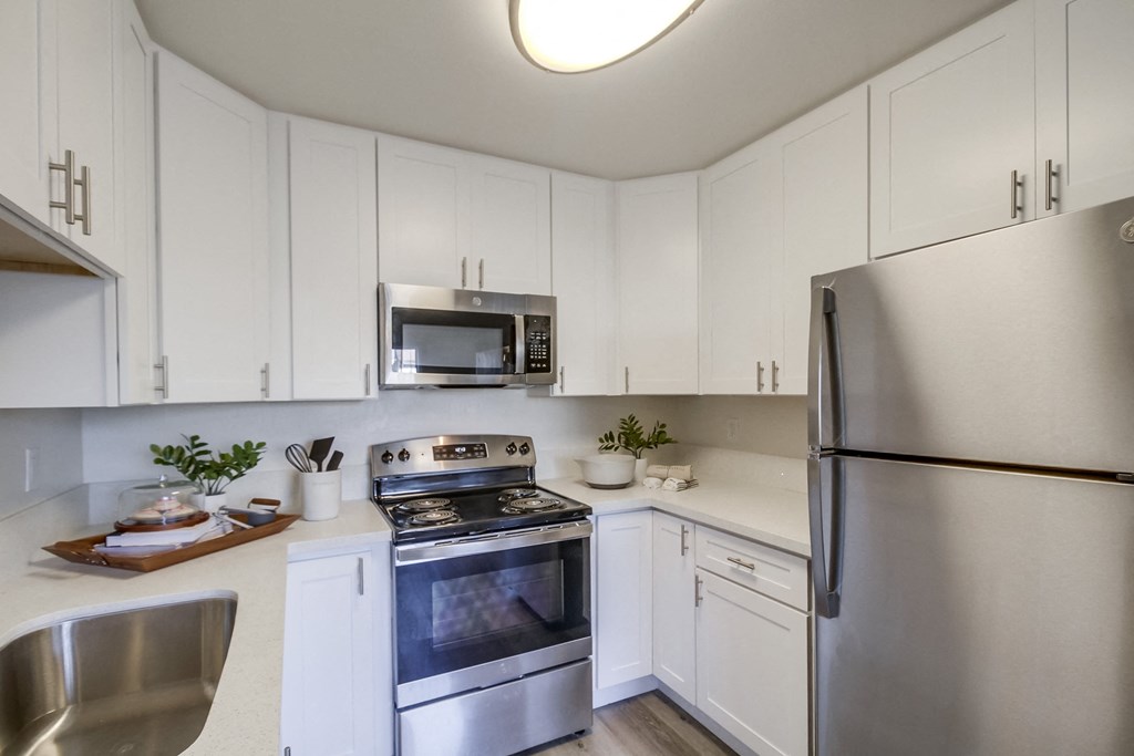 a kitchen with white cabinets and stainless steel appliances