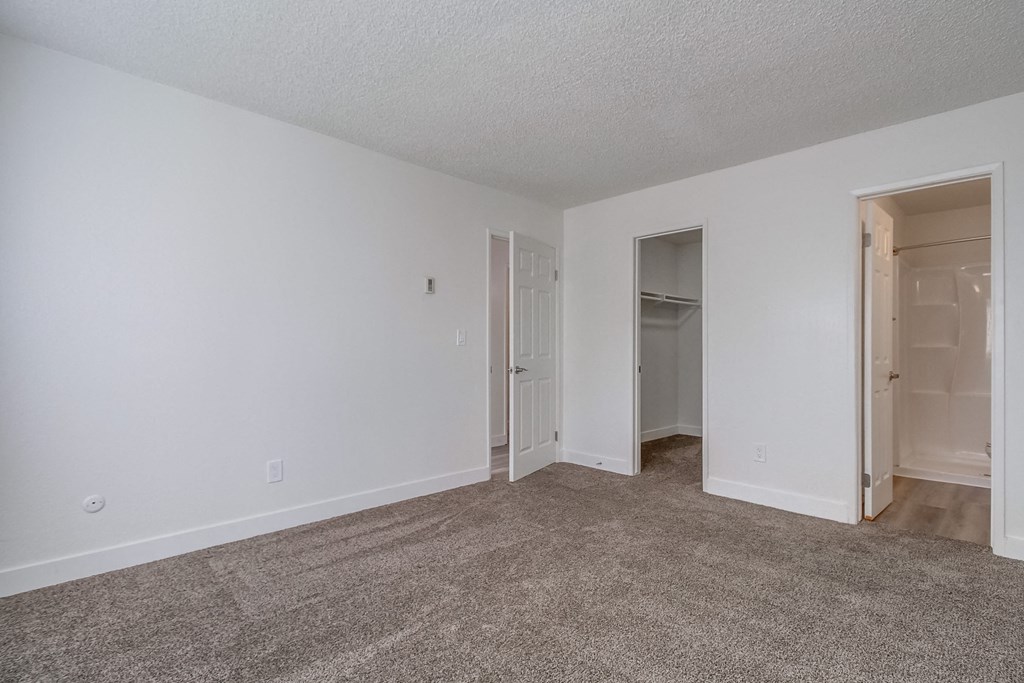 a bedroom with white walls and carpet