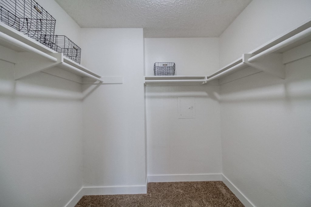 a bedroom with a medium sized closet and two shelves