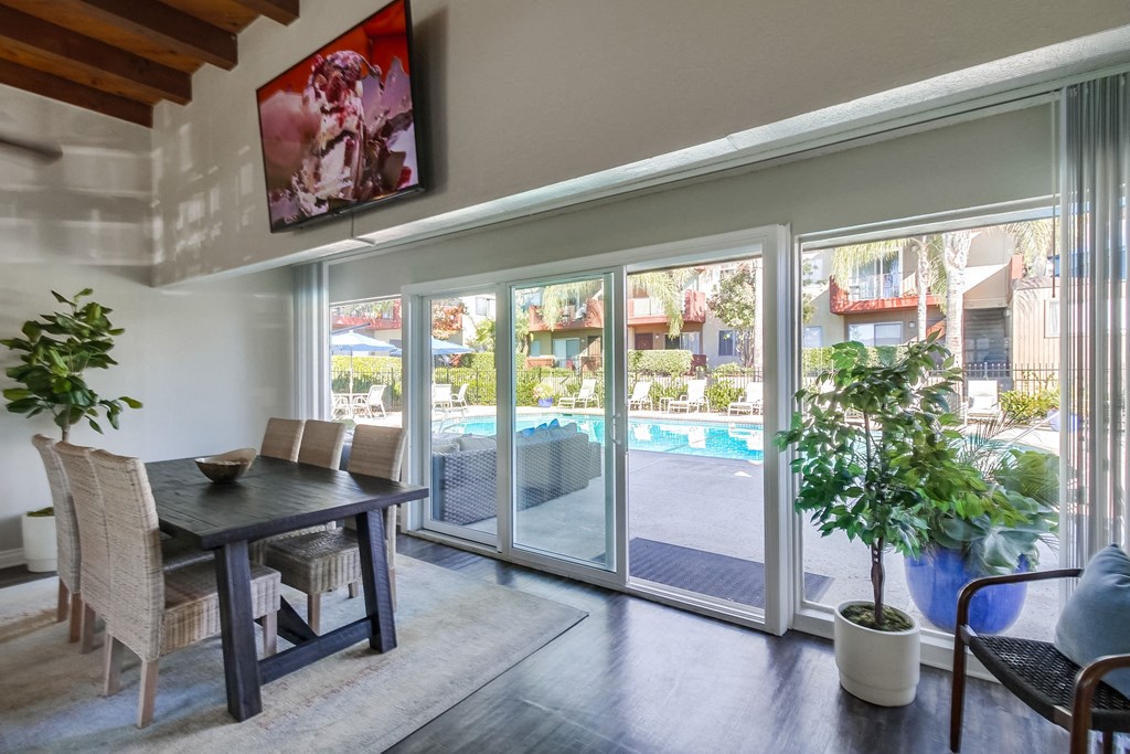 a dining area with a table and chairs and a sliding glass door leading to a pool