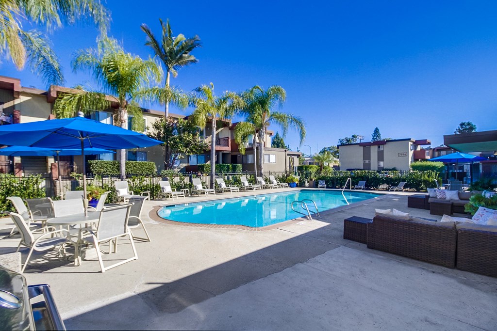 a swimming pool with lounge chairs and umbrellas