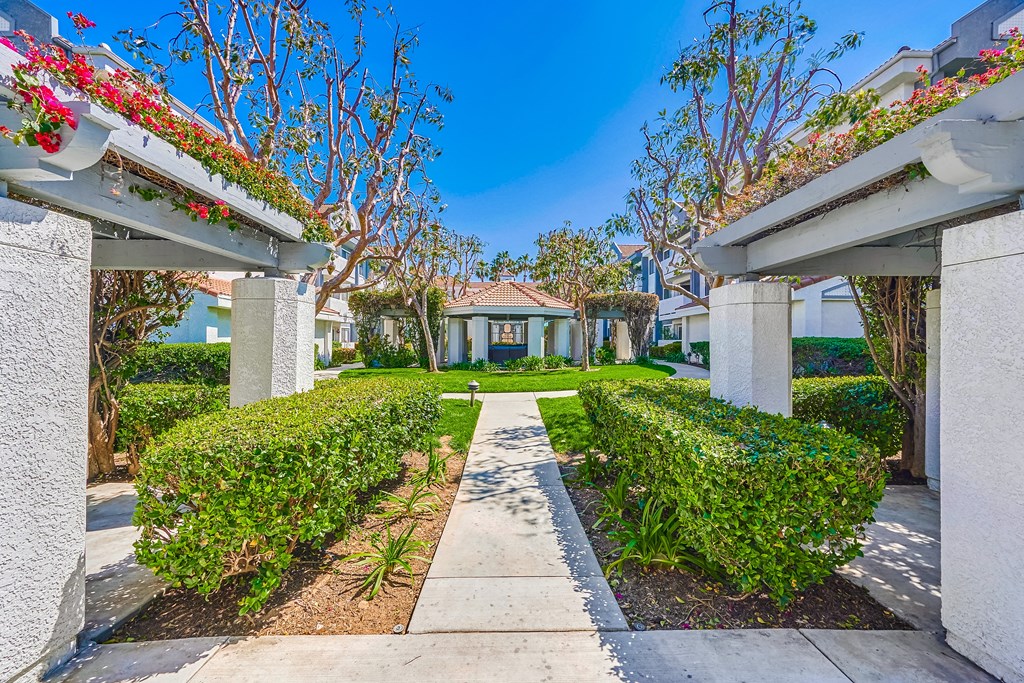 a house with a pathway and hedges in front of it