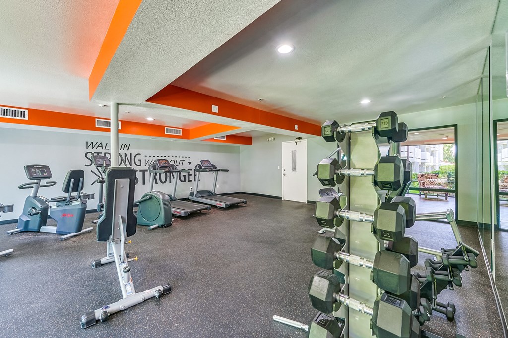 a spacious fitness center with weights and other exercise equipment