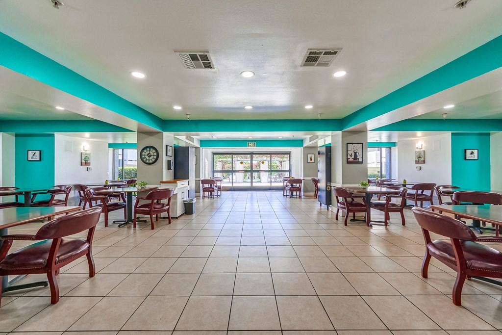 a dining area with tables and chairs and a clock on the wall