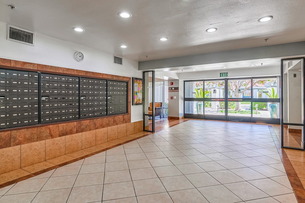 a locker room in a school with a tiled floor and a glass door with a view