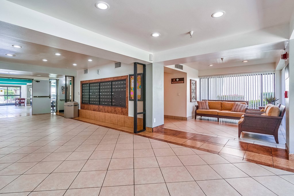 a lobby with a couch and chair and a chalkboard on the wall