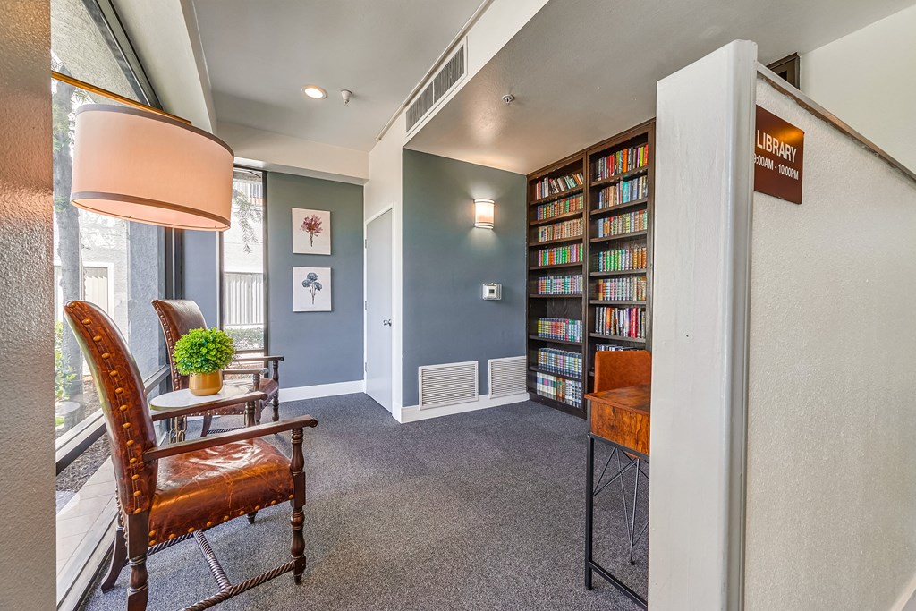 a room with a bookshelf and chairs