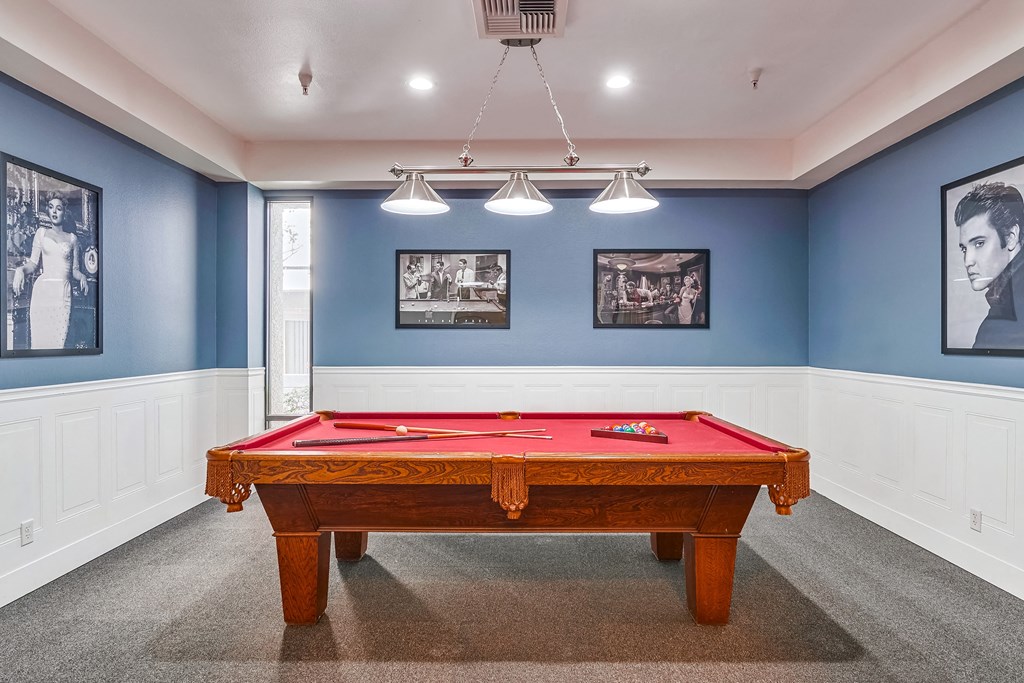 a red pool table in a blue room with pictures on the wall