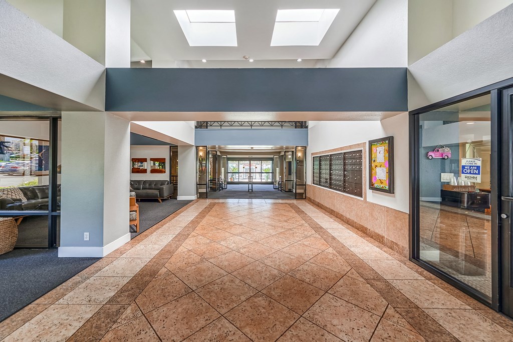 a large hallway with tile floors and a large skylight