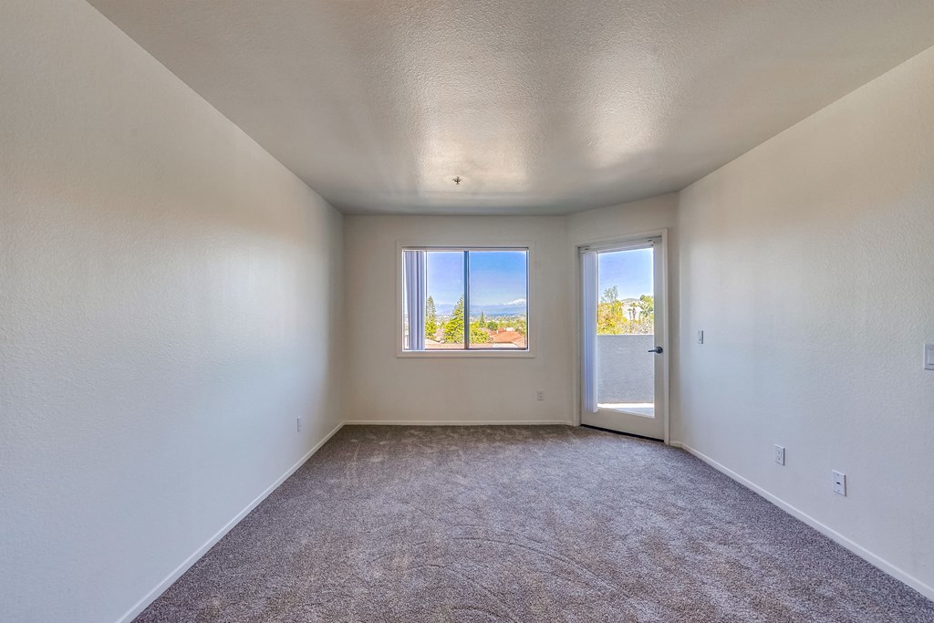an empty room with a door and a window