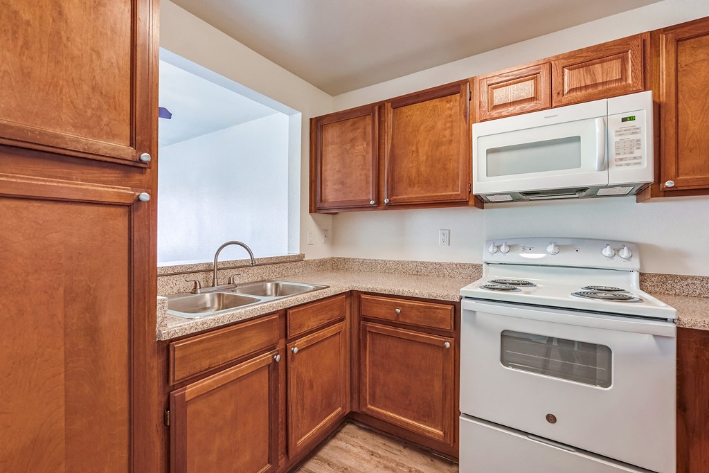 a kitchen with wooden cabinets and white appliances