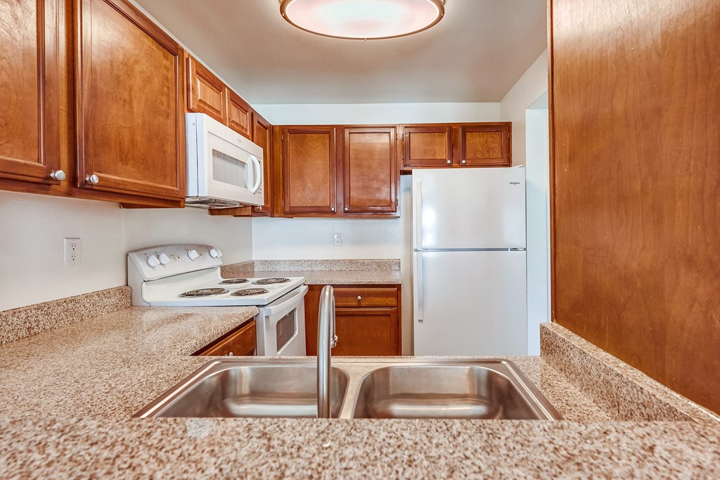 a kitchen with wooden cabinets and granite countertops