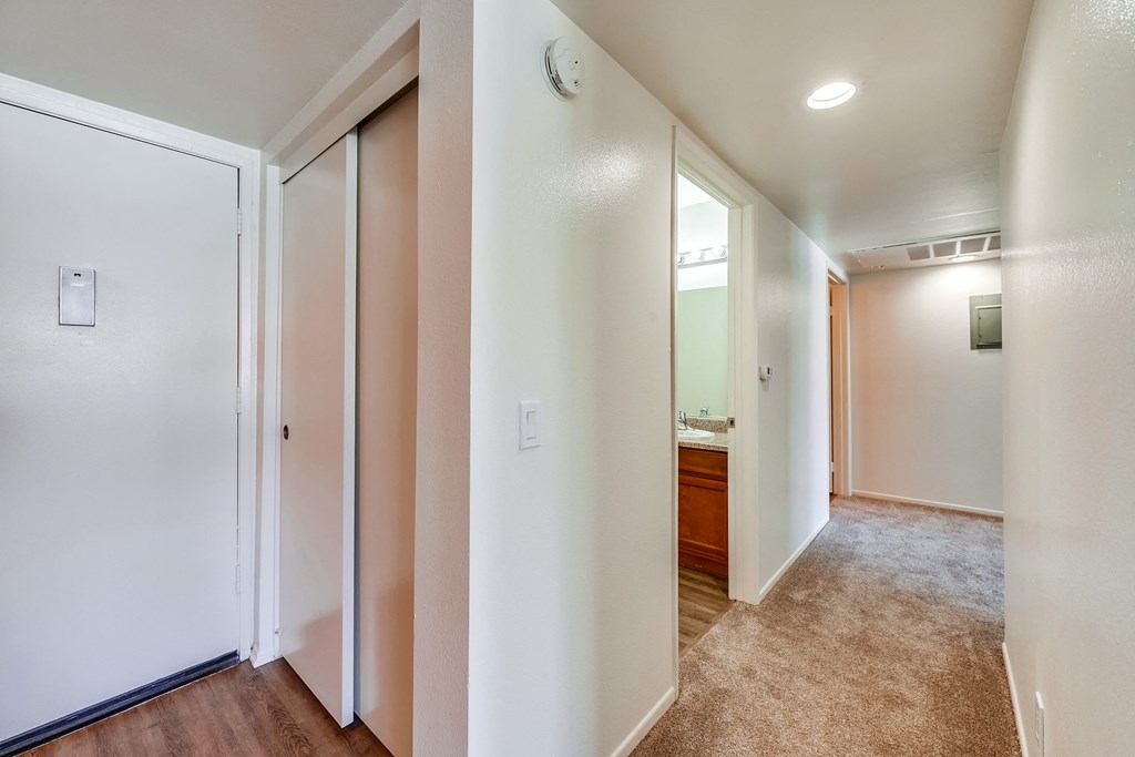 a bedroom with a medium sized bed and a mirror on the wall