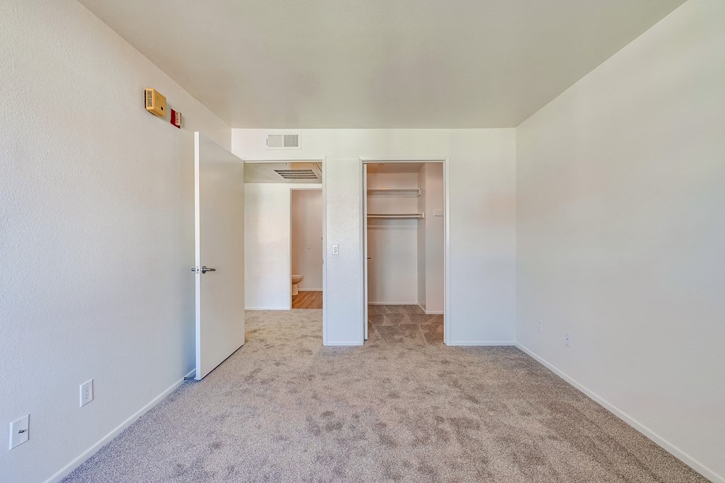 a bedroom with white walls and carpet